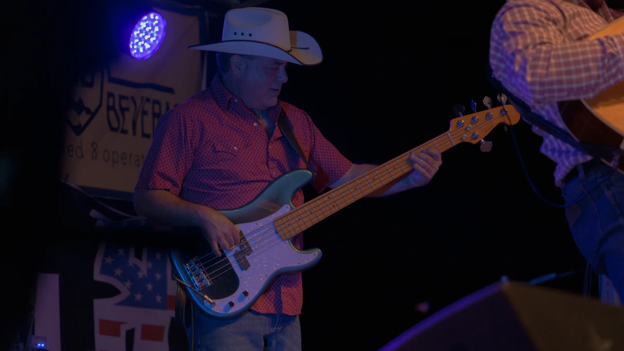 Bassist playing under blue and purple lighting