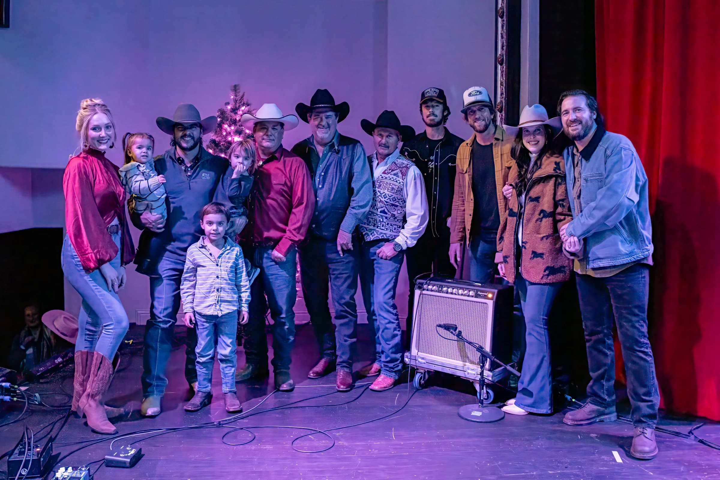 Buck Ford and a group posing together in front of the stage