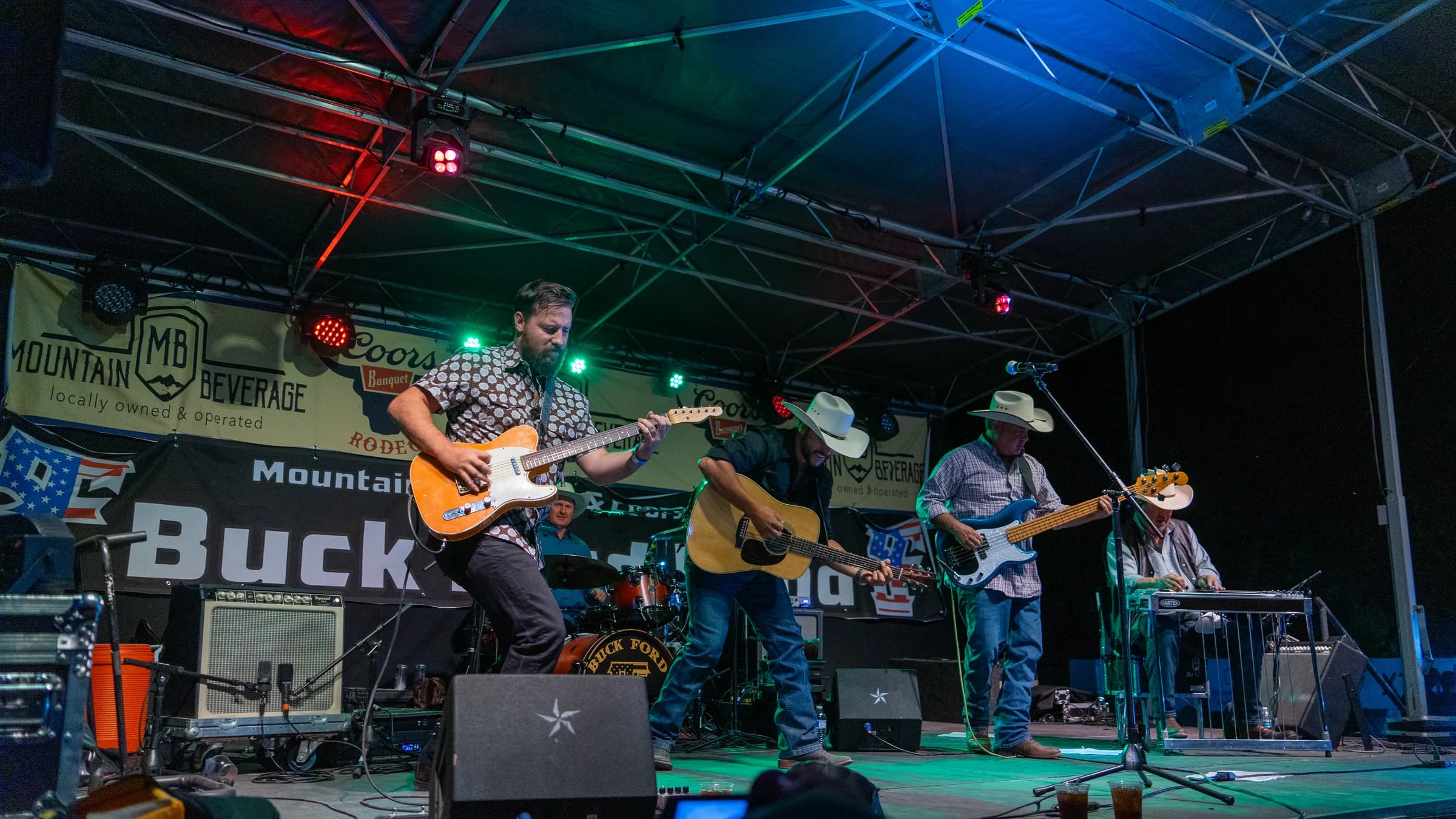 Wide view of Buck Ford and the band performing on an outdoor stage
