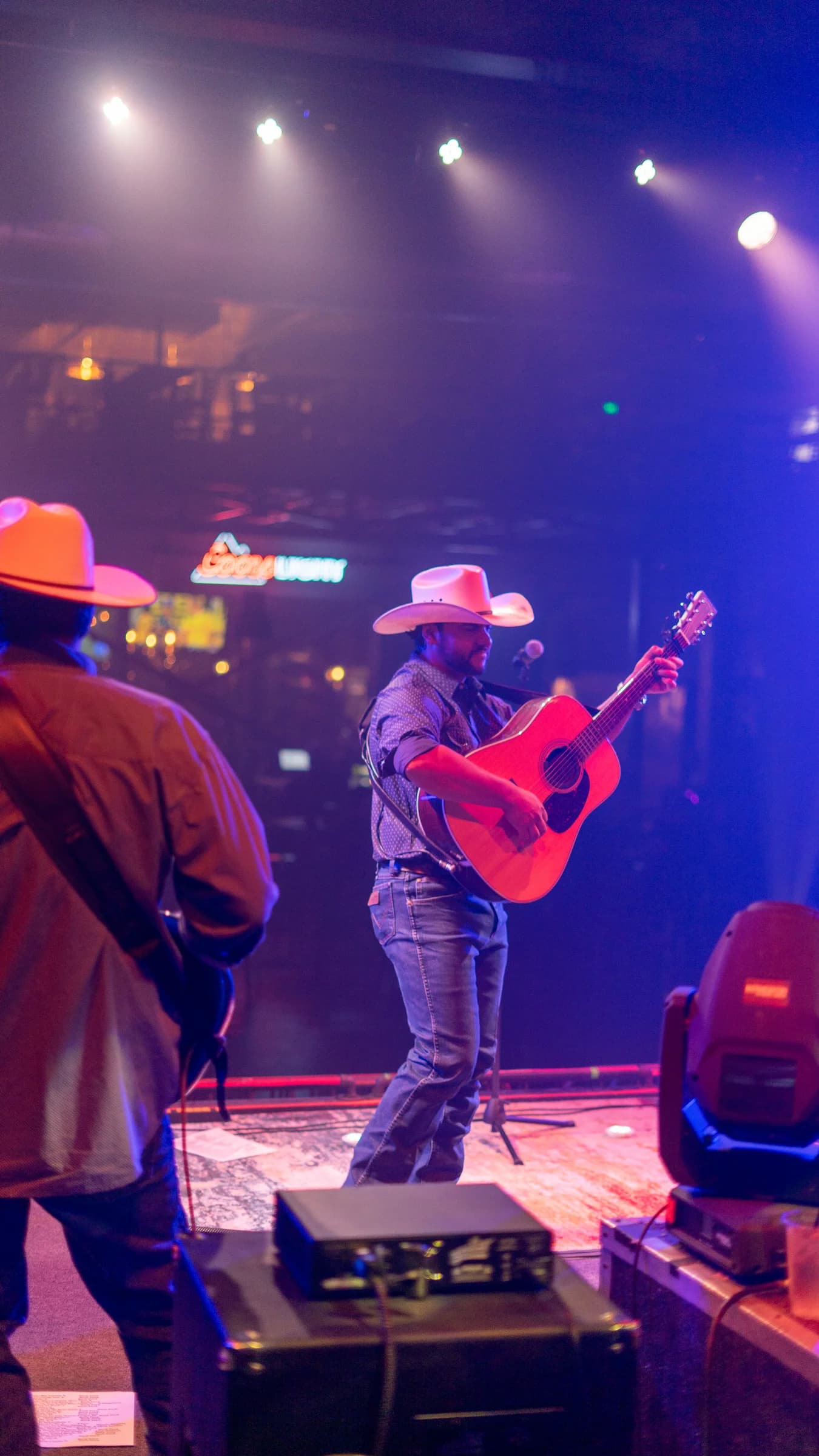 Buck Ford at the microphone under colored stage lights