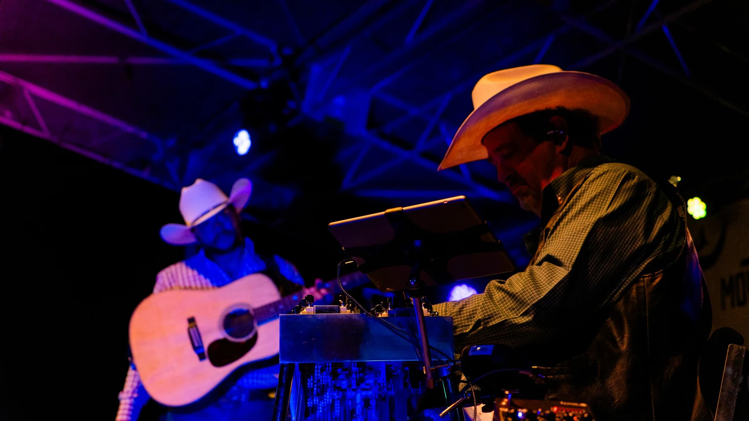 Buck Ford playing acoustic guitar beside a bandmate