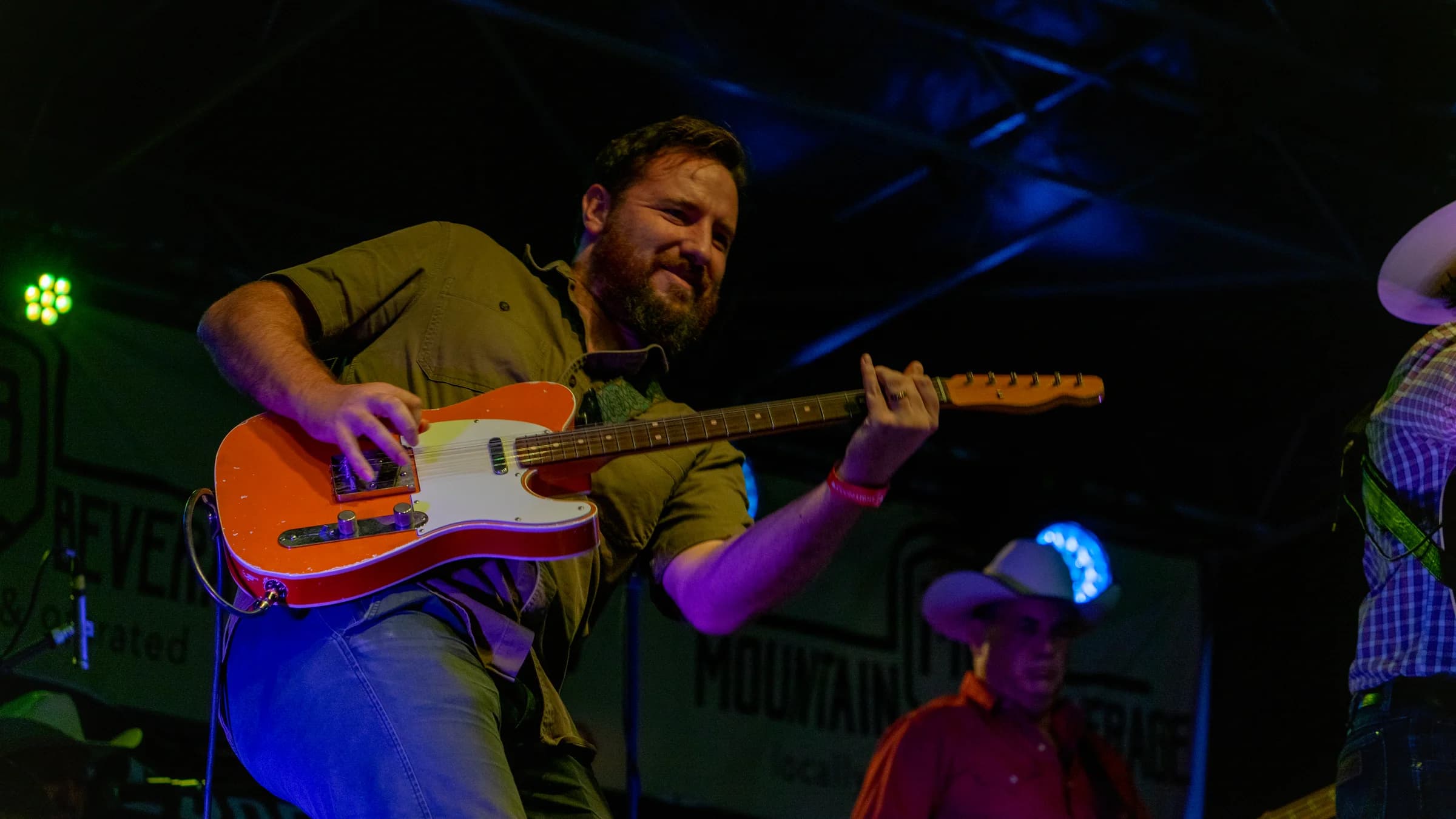 Electric guitarist playing beside a microphone stand