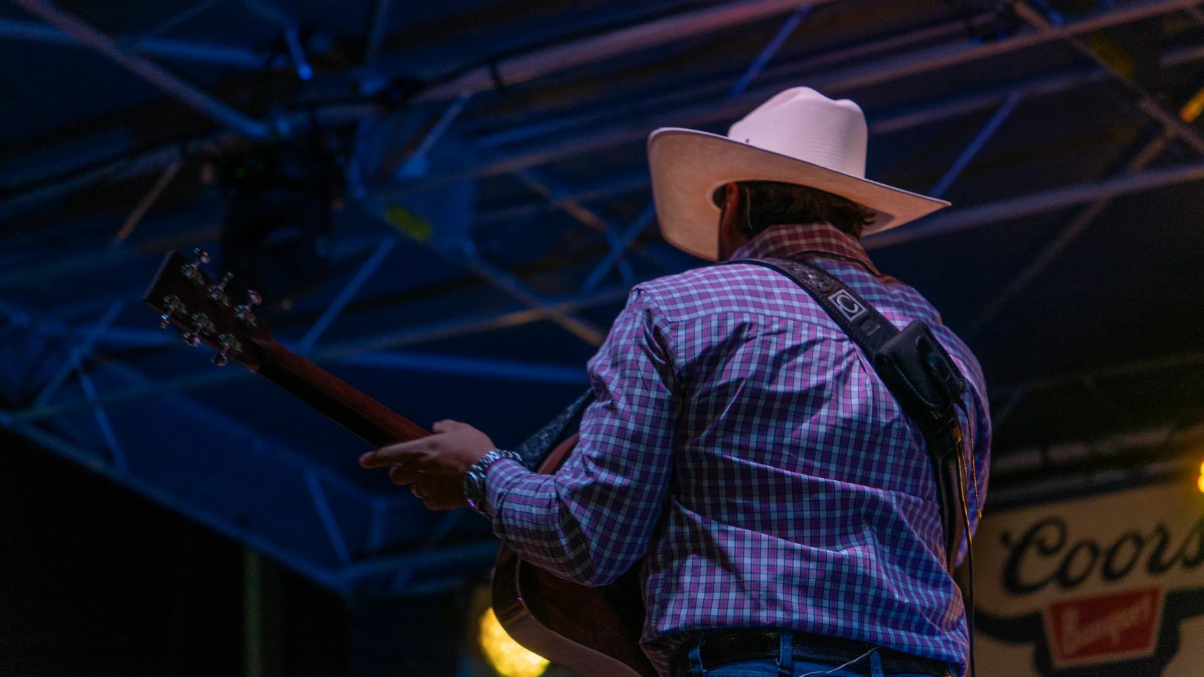 Buck Ford playing guitar, viewed from behind on stage